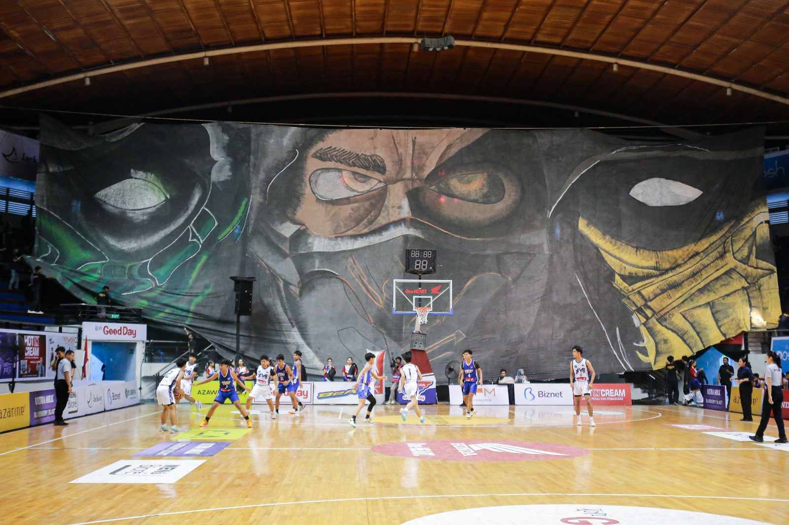 Tiga pasang mata dari tiga karakter Mortal Kombat yang menatap tajam lapangan DBL Arena