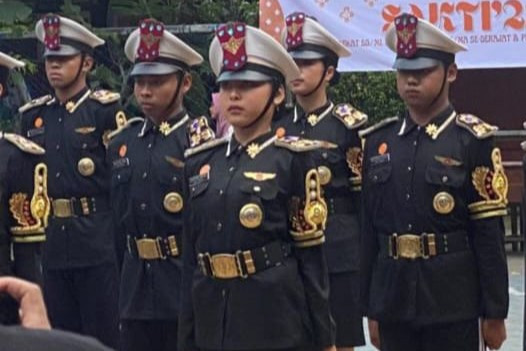 Aksi Lady (tengah) tatkala mengikuti perlombaan paskibra