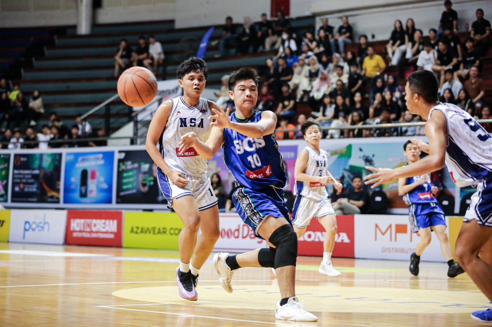 Momen Jason (jersi biru) melakukan no look pass di dalam pertandingan