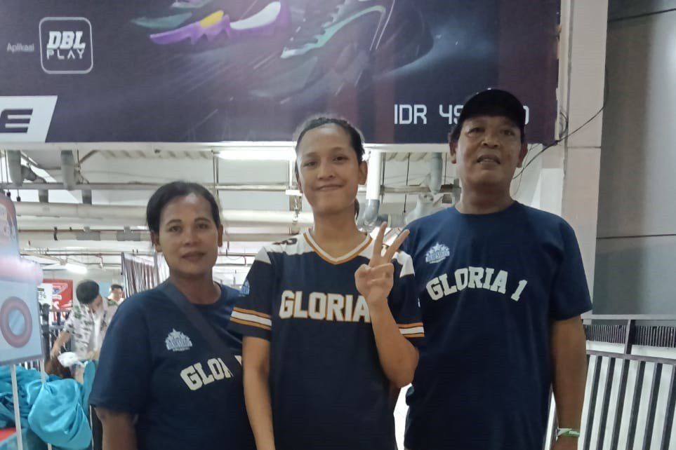 Keceriaan Ibu Puji (kiri) dan Pak Brodin (kanan) saat bersama Lyly (tengah) di pintu barat DBL Arena seusai laga