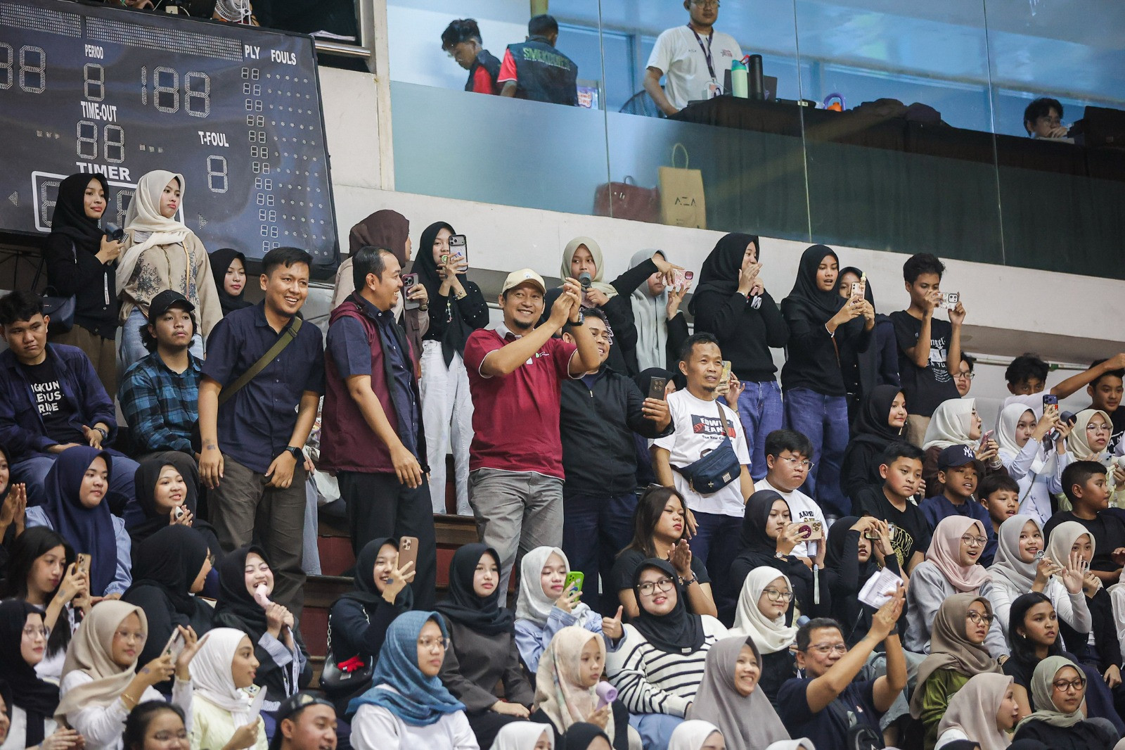 Potret Kepala Sekolah SMA Al Hikmah Surabaya, Ansari Setyo Prabowo (yang mengenakan kemeja navy berompi merah maroon), ketika mendukung siswa-siswanya secara langsung di DBL Arena Surabaya, Senin, 17 Agustus 2026