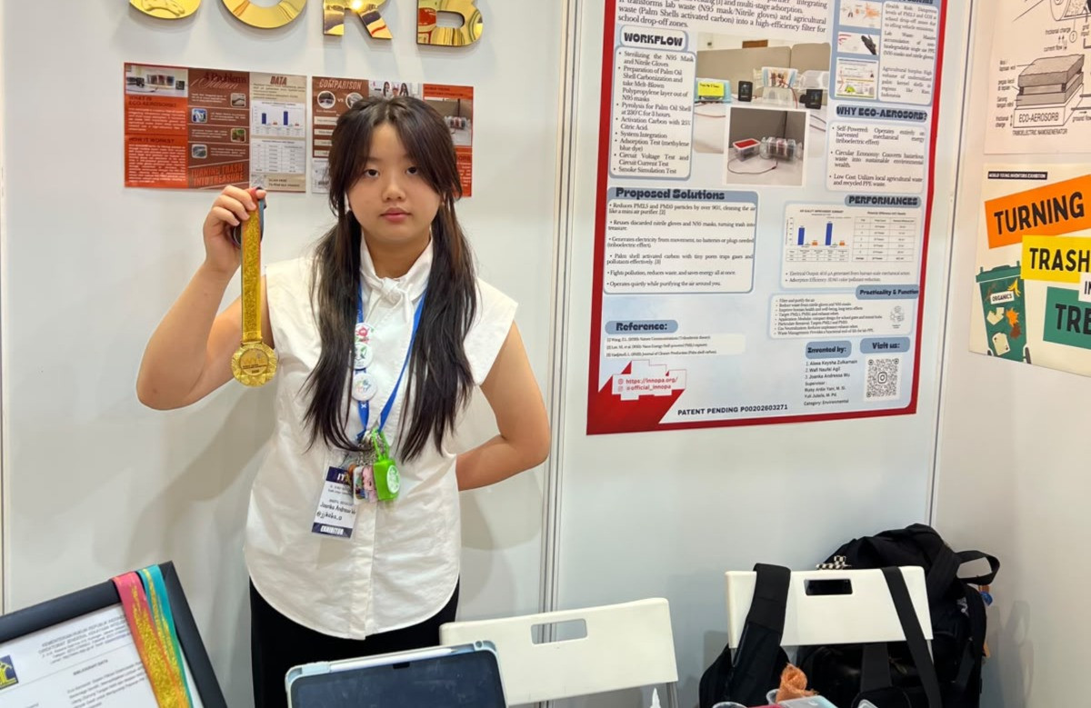 Joanka berfoto di booth inovasinya sambil memamerkan medali emas yang diraihnya dalam ajang World Young Inventors Exhibition (WYIE) 2026 (Foto: Dokumentasi pribadi Joanka Andressa Wu)